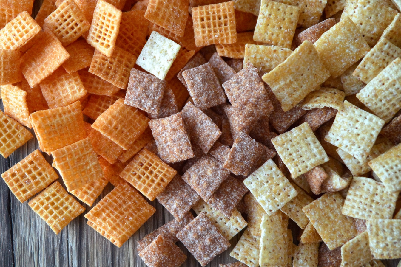 "Homemade Chex Mix with cereal, pretzels, and nuts baked to golden perfection on a tray."